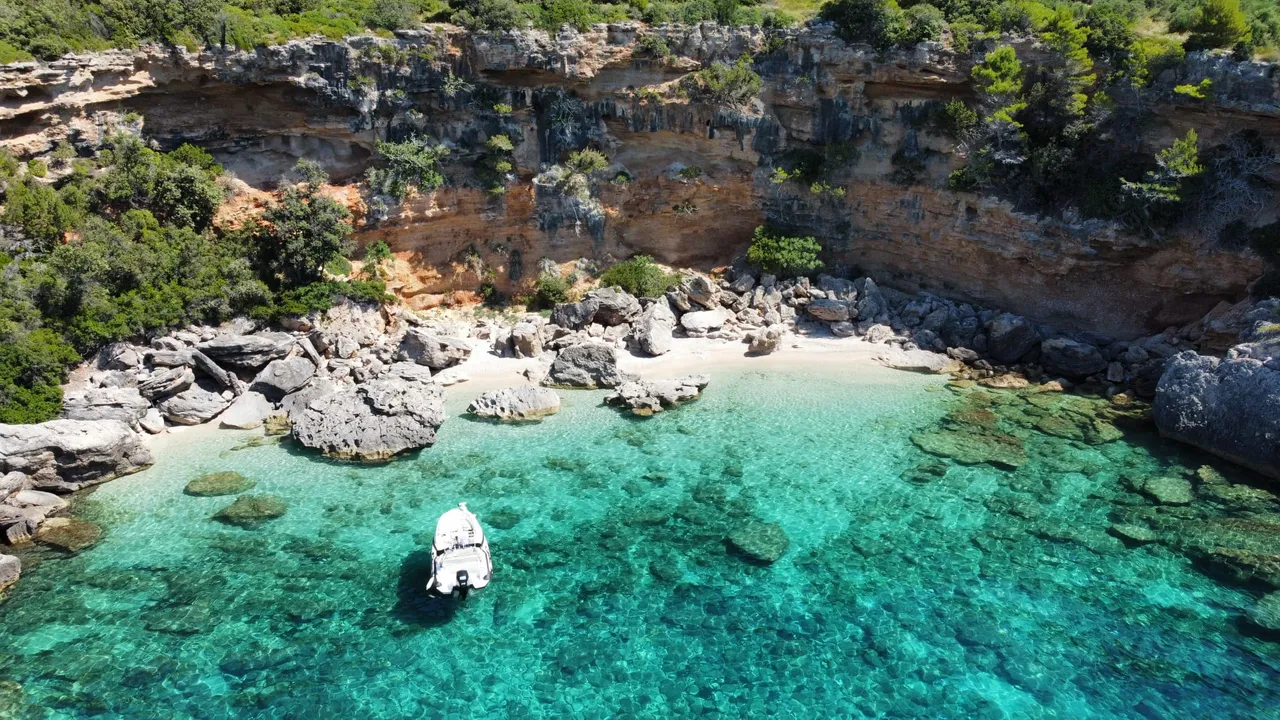 Detalj šljunka i prozirnog mora na plaži Mokalo